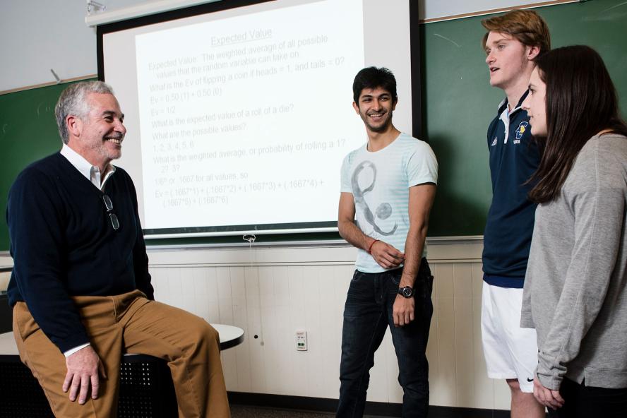 Chris Manos, Lecturer in Economics, with three students