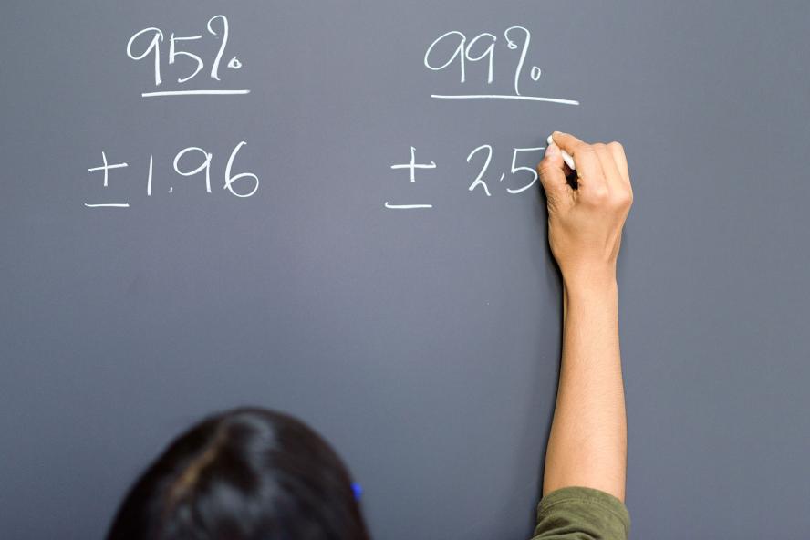 Instructor writing equation on chalkboard