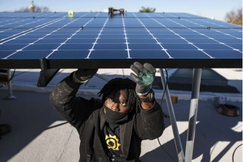 Keiron Clarke, a worker for Brooklyn SolarWorks, installs solar panels at a home in Brooklyn on Dec. 3, 2020. The firm, which serves New York City, buys solar panels through buyer collectives to get lower prices. (Karsten Moran/The New York Times)