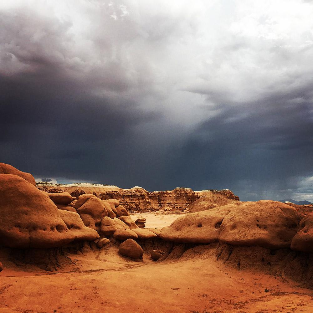 An incoming thunderstorm darkens the sky above Goblin Valley State Park, Utah