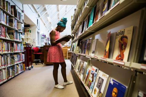 young woman perusing the magazine collection at a library
