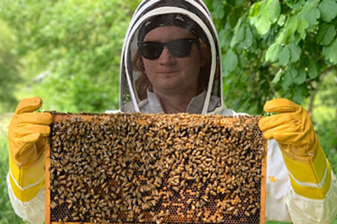student holding honeycomb with bees