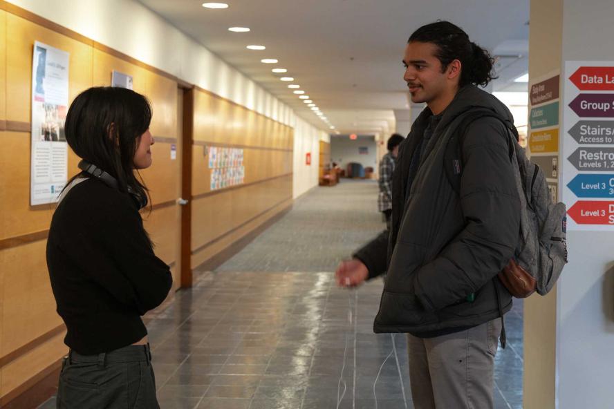 Two students talking in the lobby area of Tisch Library
