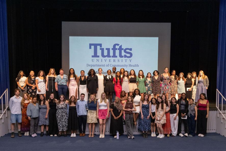 Recent graduates posing for a picture in an auditorium