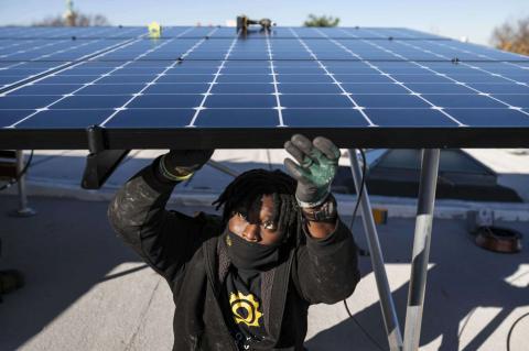 Keiron Clarke, a worker for Brooklyn SolarWorks, installs solar panels at a home in Brooklyn on Dec. 3, 2020. The firm, which serves New York City, buys solar panels through buyer collectives to get lower prices. (Karsten Moran/The New York Times)