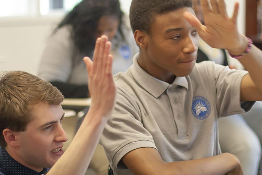 Two students raising hands