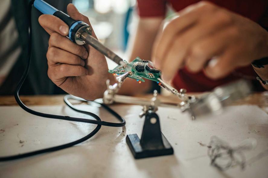 Student working on a mechanical object in a lab