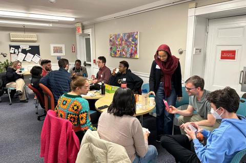 Graduate students engaged in lively conversation during the monthly gathering