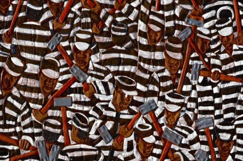 Detail of a painting of many Black men in striped clothing with hat and sledgehammer. Tufts philosophy professor Erin Kelly helps bring artist Winfred Rembert’s story to the page—a tale of loss, hardship, and resilience