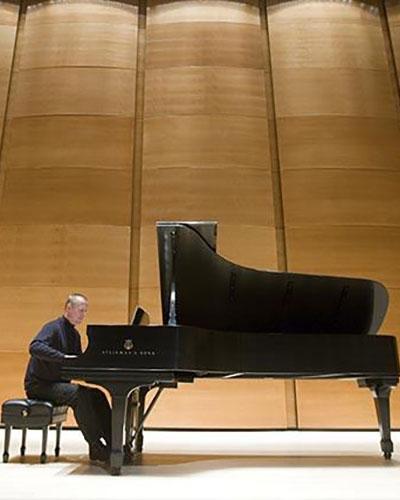 John McDonald plays grand piano at Distler Hall