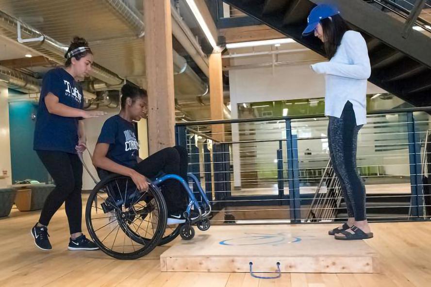 Students working with student in wheelchair