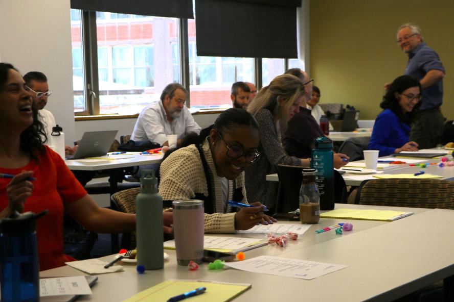 Psychology faculty members sitting at different tables in a room, working