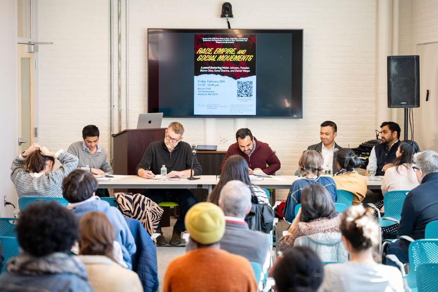 Five panelists sitting in front of a classroom