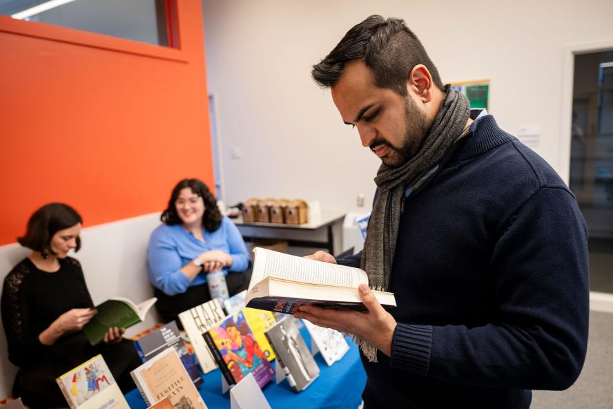 A student reading books at a Tisch Library book display