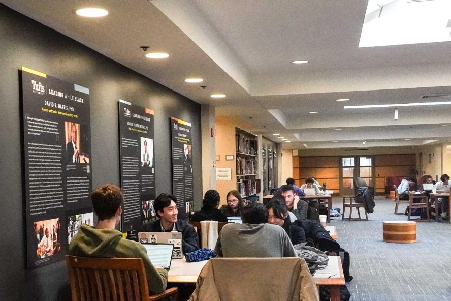 Students talking and working at a table in Tisch Library