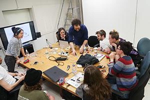 During the Rewiring Planned Obsolescence workshop, Studio Manager Ben Aron shows students how to repurpose old or broken electronics for kinetic artworks.