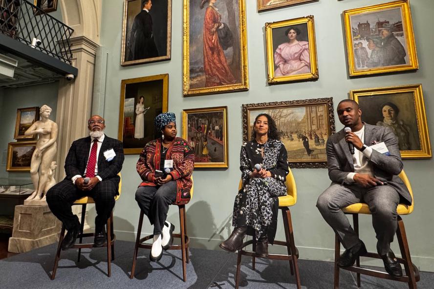 Panelist speaking in front of museum paintings