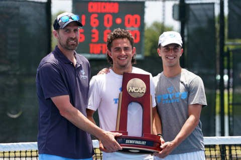 Karl Gregor and two Tufts tennis players with an NCAA trophy. Gregor received national coach of the year honor after taking the Jumbos to the NCAA Final Four for the first time this year