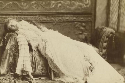 The 19th century actress Sarah Bernhardt reclining dramatically on a couch