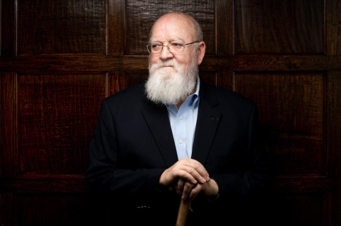 Daniel Dennett with a roughly carved wood cane. The longtime philosophy professor recounts his eventful life, celebrates evolution, and issues a warning about what’s really dangerous about AI