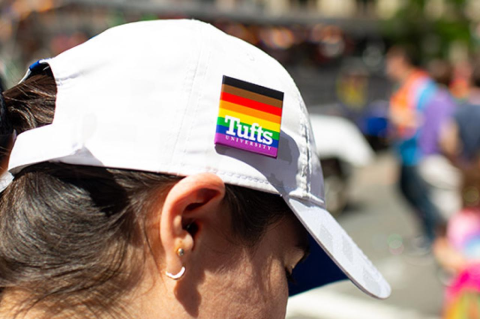 Tufts University student has a Tufts Pride Day pin on hat