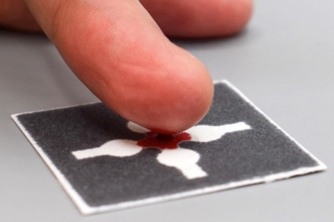 A finger leaving a bit of blood on a piece of paper. Inexpensive, shelf-stable, easy-to-use tests bring lab-level precision to the home and field for blood, water, and lactic acid in sweat tests