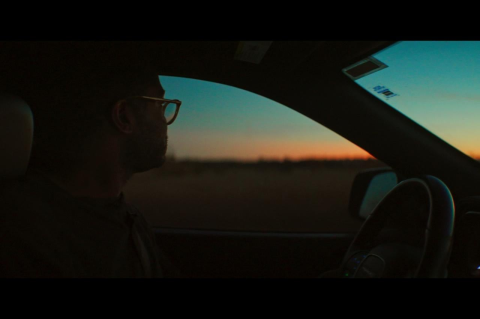 a man in his car looks at the horizon