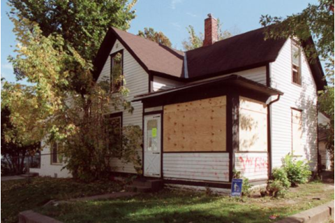 Abandoned two-storey home that is boarded up against trespassers.